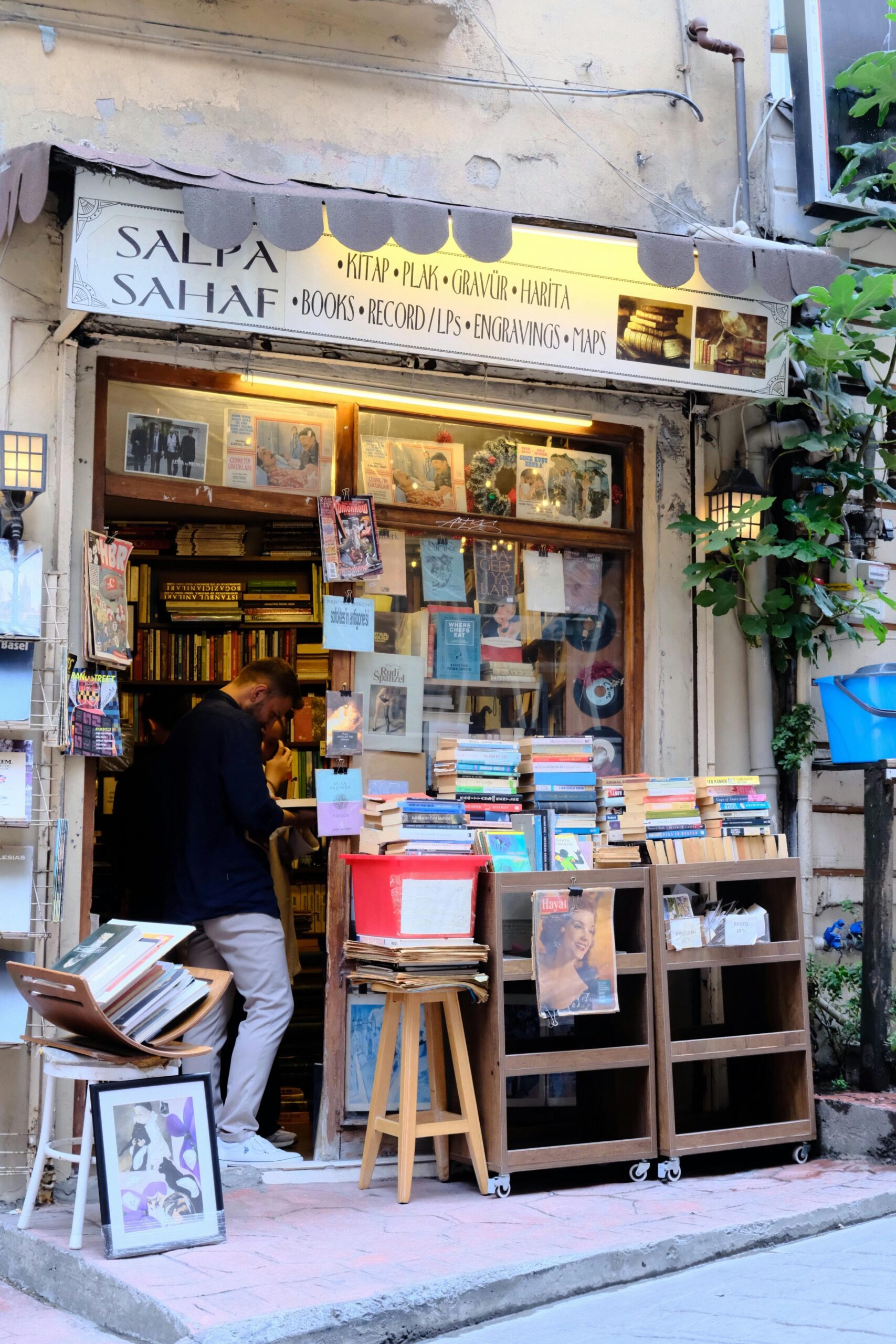 Quaint bookshop with books, vinyls, and maps on sale in a lively Istanbul street.